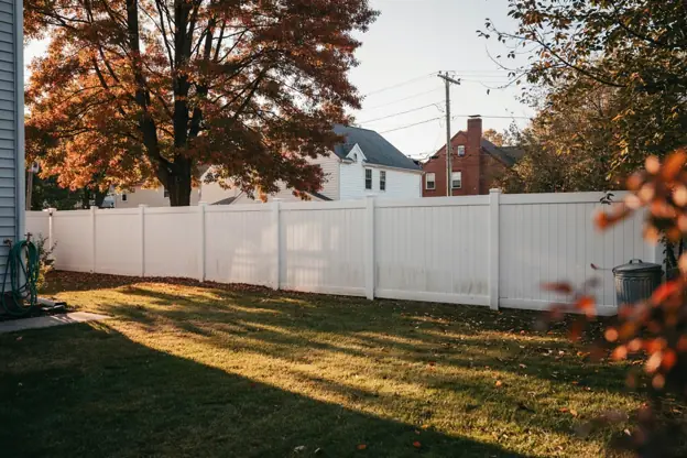Vinyl-fenced backyard in a dense North Jersey suburb with oaks in autumn color