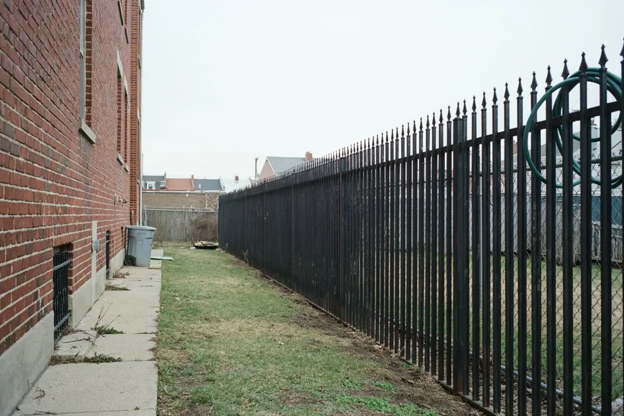 Ornamental iron fence behind a North Jersey row house