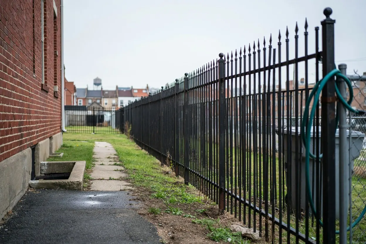 Ornamental iron fence behind a North Jersey row house