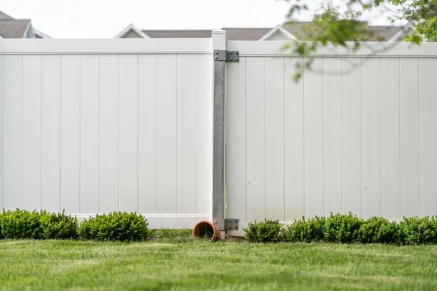 White vinyl privacy fence panel and gate in a New Jersey backyard